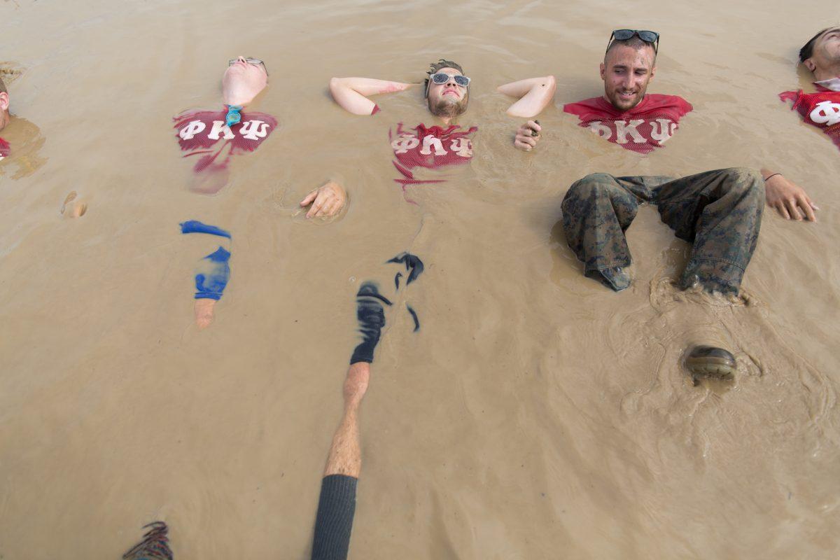 Rochester Institute of Technology students Josh Torrey (left), Scott Jacoby (center) and Luke Kehrli (right) lay in the mud at the annual mud tug event held at RIT in Henrietta, N.Y. on Sept. 19, 2015. Photography by Dominique Hessert