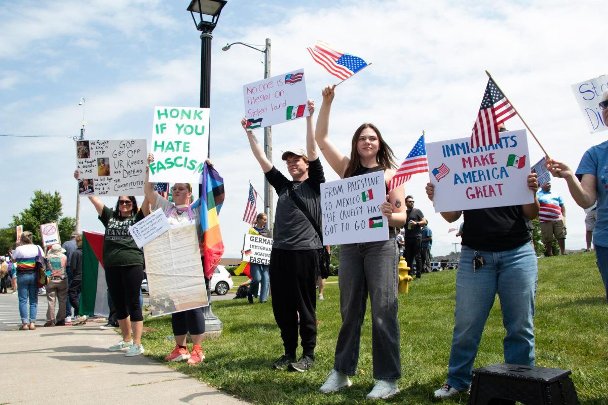 Demonstrators hold American flags and signs during 'No Kings' protests on June 14, 2025, in Henrietta, N.Y..