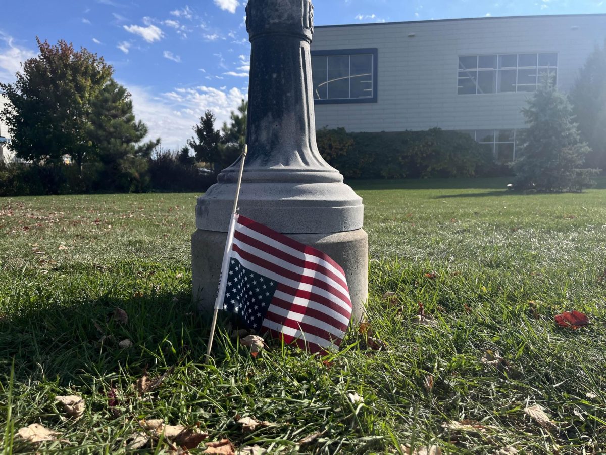 An upside down U.S. flag sits at the bottom of a lamppost at the 'No Kings Protest' in Henrietta, N.Y. on Oct. 18, 2025.
